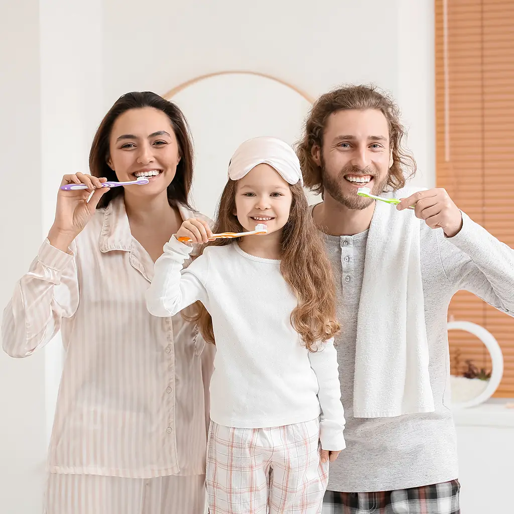 Familie im Pyjama beim gemeinsamen Zähneputzen